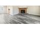 Bright living room featuring a cozy fireplace and modern gray wood flooring at 5422 Timor Trl, Lithonia, GA 30038
