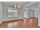 Spacious dining area featuring hardwood floors, detailed trim work, a modern chandelier, and large windows at 56 Addison Woods Dr, Sugar Hill, GA 30518