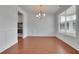 Elegant dining room with hardwood floors, decorative moldings, modern chandelier and bright natural light at 56 Addison Woods Dr, Sugar Hill, GA 30518