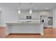 Modern kitchen with white cabinets, stainless steel appliances, a large island, and granite countertops at 56 Addison Woods Dr, Sugar Hill, GA 30518
