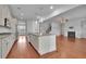 Spacious open-concept kitchen with granite countertops, a large island, white cabinetry, and modern appliances at 56 Addison Woods Dr, Sugar Hill, GA 30518