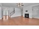 Bright living room featuring hardwood floors, a fireplace, and an open staircase at 56 Addison Woods Dr, Sugar Hill, GA 30518