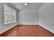 Bright and airy room featuring hardwood floors, white trim, a large window, and ample natural light at 56 Addison Woods Dr, Sugar Hill, GA 30518