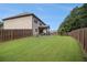 Spacious backyard with a well-manicured lawn, wooden fence, and covered patio, perfect for outdoor living and entertaining at 5925 Whitney Ct, Cumming, GA 30041