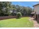 Expansive green backyard enclosed by a tall wooden fence, and shady trees at 5925 Whitney Ct, Cumming, GA 30041