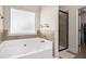Bathroom showcases a tub beneath a window, and adjacent glass-enclosed shower at 5925 Whitney Ct, Cumming, GA 30041