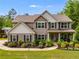 Charming two-story home with a manicured front yard, lush landscaping, and inviting covered front porch with chairs at 13 Westbrook Rd, Carrollton, GA 30116