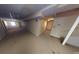 This basement features neutral walls, carpet, and lighting, with a door leading to another room at 3692 Belmont Abbey Dr, Decatur, GA 30034