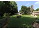 Expansive backyard with lush landscaping, a storage shed, and outdoor dining area at 4687 Riley Run Ct, Sugar Hill, GA 30518