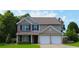 Charming two-story home featuring a brick and vinyl facade, well-manicured lawn, and a two-car garage at 4687 Riley Run Ct, Sugar Hill, GA 30518