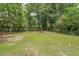 Large, grassy backyard with mature trees and partially fenced perimeter at 2621 Gordon Se Cir, Smyrna, GA 30080