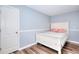 Cozy bedroom with light blue paint features a door to the left and is well lit from the ceiling and window at 630 Beckenham Walk Dr, Dacula, GA 30019