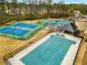 Aerial view of community pool and tennis courts featuring a pool with safety cover, playground, and well-kept tennis courts at 630 Beckenham Walk Dr, Dacula, GA 30019