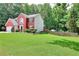 A view of the well-manicured lawn and tree-lined backyard behind this charming two-story home at 630 Beckenham Walk Dr, Dacula, GA 30019