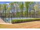 Well-maintained community tennis court surrounded by trees and lush landscaping with nearby benches providing shade at 630 Beckenham Walk Dr, Dacula, GA 30019