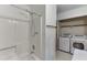 Bathroom featuring a shower-tub, adjacent laundry machines, and a functional design for convenience at 859 Sangria Ct, Lawrenceville, GA 30043