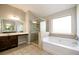 Bright primary bathroom with tub, shower, and double vanity sink at 1021 Reddy Farm Rd, Grayson, GA 30017