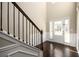 Bright foyer featuring hardwood floors, staircase with iron spindles, wainscotting, and natural light at 1021 Reddy Farm Rd, Grayson, GA 30017