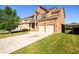 Angle view of the two-story brick home with an extended driveway, landscaped yard, and attached two-car garage at 1021 Reddy Farm Rd, Grayson, GA 30017