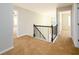 Upstairs hallway with carpet, wrought iron railing and white doors at 1021 Reddy Farm Rd, Grayson, GA 30017