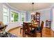 Charming dining room features a wooden table set, hardwood floors, and natural light from large windows at 2111 Yorkshire Ct, Woodstock, GA 30189
