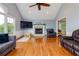 Cozy living room with hardwood floors, fireplace, and natural light from multiple windows at 2111 Yorkshire Ct, Woodstock, GA 30189
