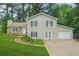 Two-story home featuring light siding, stone accents, attached garage, and a well-manicured front lawn at 2959 Pritchards Mill Trl, Douglasville, GA 30135