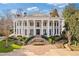 Stately home featuring a grand entrance with symmetrical staircases, manicured gardens, and impressive architectural details at 3977 Sweet Bottom Dr, Duluth, GA 30096