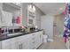 Bathroom featuring dual sinks, granite countertops, and a glass-enclosed shower at 855 Peachtree Ne St # 1703, Atlanta, GA 30308