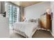 Cozy bedroom with a large window offering stunning city views, complemented by comfortable decor at 855 Peachtree Ne St # 1703, Atlanta, GA 30308