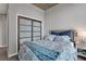 Comfortable bedroom features a plush patterned duvet, a sliding door closet, and a neutral gray color scheme at 855 Peachtree Ne St # 1703, Atlanta, GA 30308