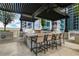 Outdoor grilling area with multiple grills, bar seating, and a pergola with city skyline views at 855 Peachtree Ne St # 1703, Atlanta, GA 30308