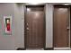 Hallway with modern doors, textured wallpaper, and a fire extinguisher mounted in a metal frame at 855 Peachtree Ne St # 1703, Atlanta, GA 30308