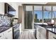 Contemporary kitchen featuring granite countertops, farmhouse sink, and city views through expansive windows at 855 Peachtree Ne St # 1703, Atlanta, GA 30308