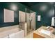 Stylish bathroom with a glass-enclosed shower, soaking tub, elegant vanity, and dark green accent wall at 870 Inman Village Ne Pkwy # 305, Atlanta, GA 30307