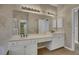 Bright bathroom features a dual vanity with neutral countertops, undermount sinks and large mirror at 1215 Wynridge Xing, Alpharetta, GA 30005