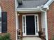 Up-close front door view featuring black door, sidelights, and brick exterior at 3690 Crescent Walk Ln, Suwanee, GA 30024