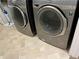 LG washer and dryer set in laundry room with neutral tile flooring at 3690 Crescent Walk Ln, Suwanee, GA 30024