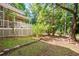 Large, private backyard featuring a covered porch, lush greenery, and mature trees at 4259 Kings Troop Rd, Stone Mountain, GA 30083