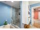 Modern bathroom featuring a walk-in shower with glass enclosure, wall shelves, and tile flooring at 4259 Kings Troop Rd, Stone Mountain, GA 30083