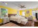 Bright bedroom with yellow walls, a ceiling fan, wood floors, and natural light at 4259 Kings Troop Rd, Stone Mountain, GA 30083