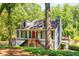 Two-story home featuring a striking red front door, charming architecture, and lush surroundings at 4259 Kings Troop Rd, Stone Mountain, GA 30083