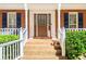 Covered front porch entrance with brick steps, columns, and a storm door at 4259 Kings Troop Rd, Stone Mountain, GA 30083