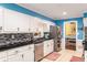 This bright kitchen boasts white cabinets, stainless steel appliances and backyard views at 4259 Kings Troop Rd, Stone Mountain, GA 30083
