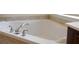 Close-up of a white bathtub with chrome fixtures and a tiled surround at 430 English Ivy Way, Woodstock, GA 30188