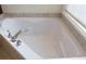 Close up of a white bathtub with chrome fixtures and a tiled surround at 430 English Ivy Way, Woodstock, GA 30188