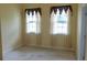 Bedroom showcasing two windows with decorative curtains and neutral carpet at 430 English Ivy Way, Woodstock, GA 30188