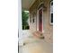 Inviting front porch with brick steps leading to a striking red door and elegant wall lanterns at 430 English Ivy Way, Woodstock, GA 30188