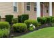 Charming home featuring a manicured front yard with lush green bushes and a vibrant red door at 430 English Ivy Way, Woodstock, GA 30188