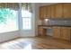 Cozy kitchen nook with a built-in desk, cabinets, hardwood floors, and a bay window with a backyard view at 430 English Ivy Way, Woodstock, GA 30188